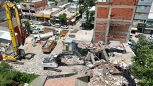 Yıkılan binanın parçaları iş yerinin üzerine düştü