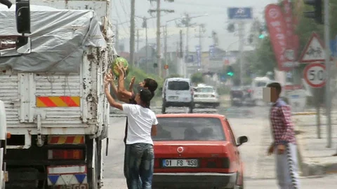 Adana'da çocukların kırmızı ışıkta bekleyen bir kamyondan karpuz çaldığı anlar güvenlik kameralarına yansıdı.