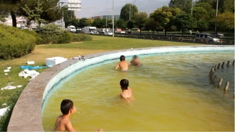 Bursa'da okulların kapanmasıyla birlikte çocuklar süs havuzlarına akın etti.