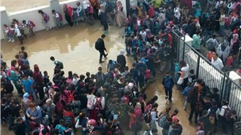 Yağmur yağınca okul bahçesi havuza döndü, öğrenciler tahta üzerinde yürüdü