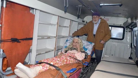 95'lik Veysel dede, yatalak eşini sedyeyle sandık başına getirdi