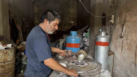 Gaziantep'te kalaycılık mesleğini 58 yıldır sürdüren Ateş, geleneksel yöntemlerle mutfak eşyalarını kalaylayarak eski özlerini koruyor.