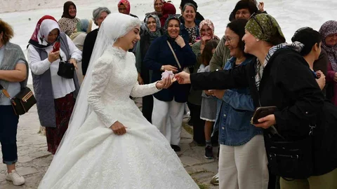 Denizli'de düğün çekimi için Pamukkale'ye giden çift, turistlerin takı kuyruğuna uğradı.