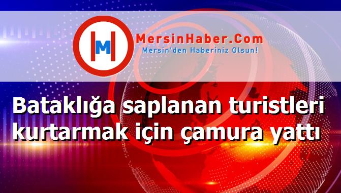 Bataklığa saplanan turistleri kurtarmak için çamura yattı